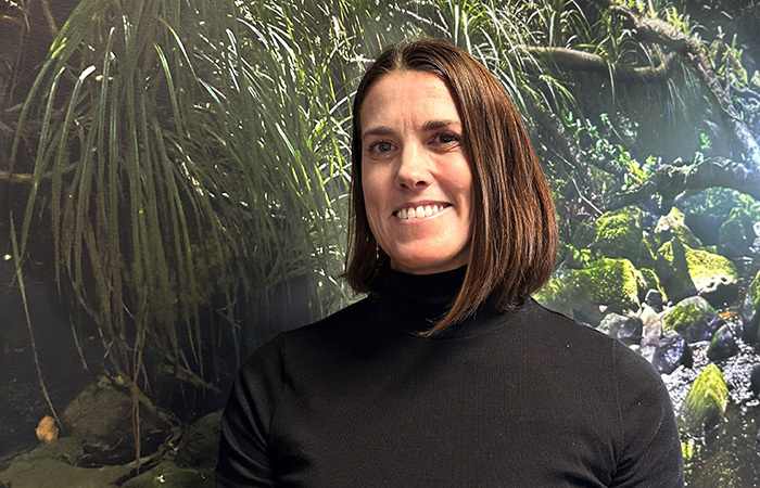 Zeralda Pirini standing in front of a bush scene.