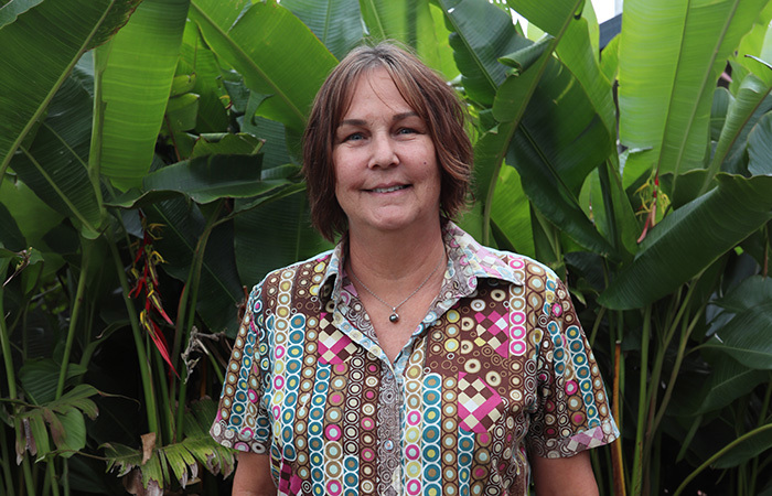 Susan Karels standing in front of a garden in the park.