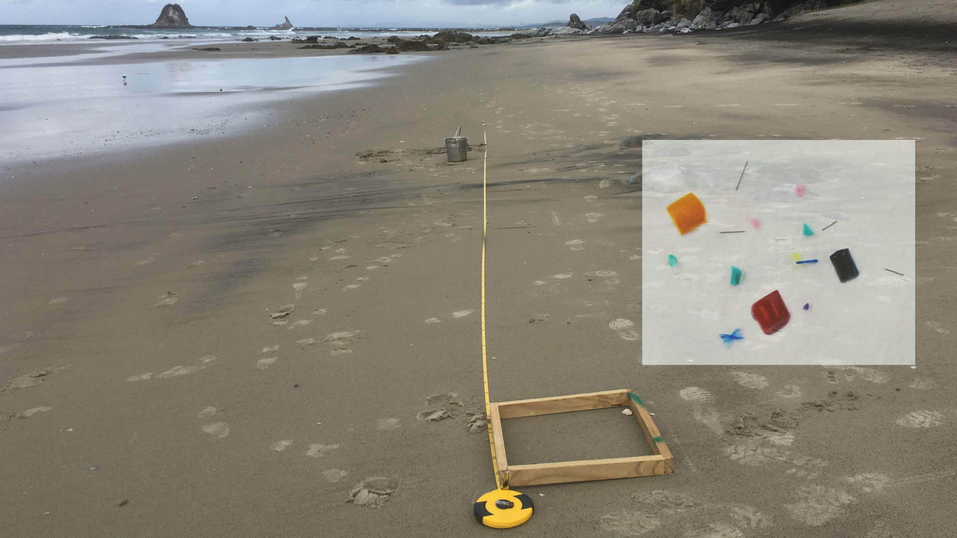 A tape measure line on a beach with an overlaid inset image of microplastics.