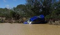 Car swept off the road by flooding on State Highway 1.