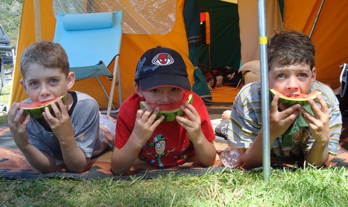 Kids eating watermelon.