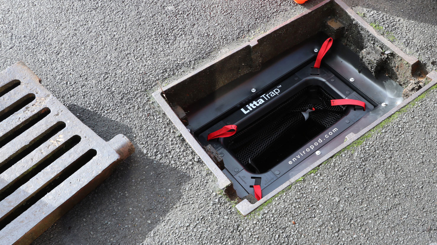 A LittaTrap installed into a drain in a carpark with the drain grate sitting alongside.