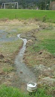 Wastewater being discharged onto an empty site.