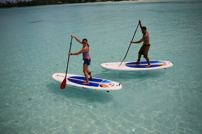Two people standing on paddleboards. Two people standing on paddleboards.