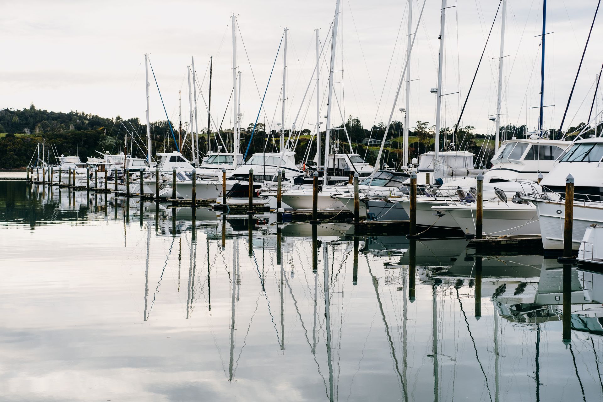 Launches and recreational watercraft tied up to mooring poles in a marina.