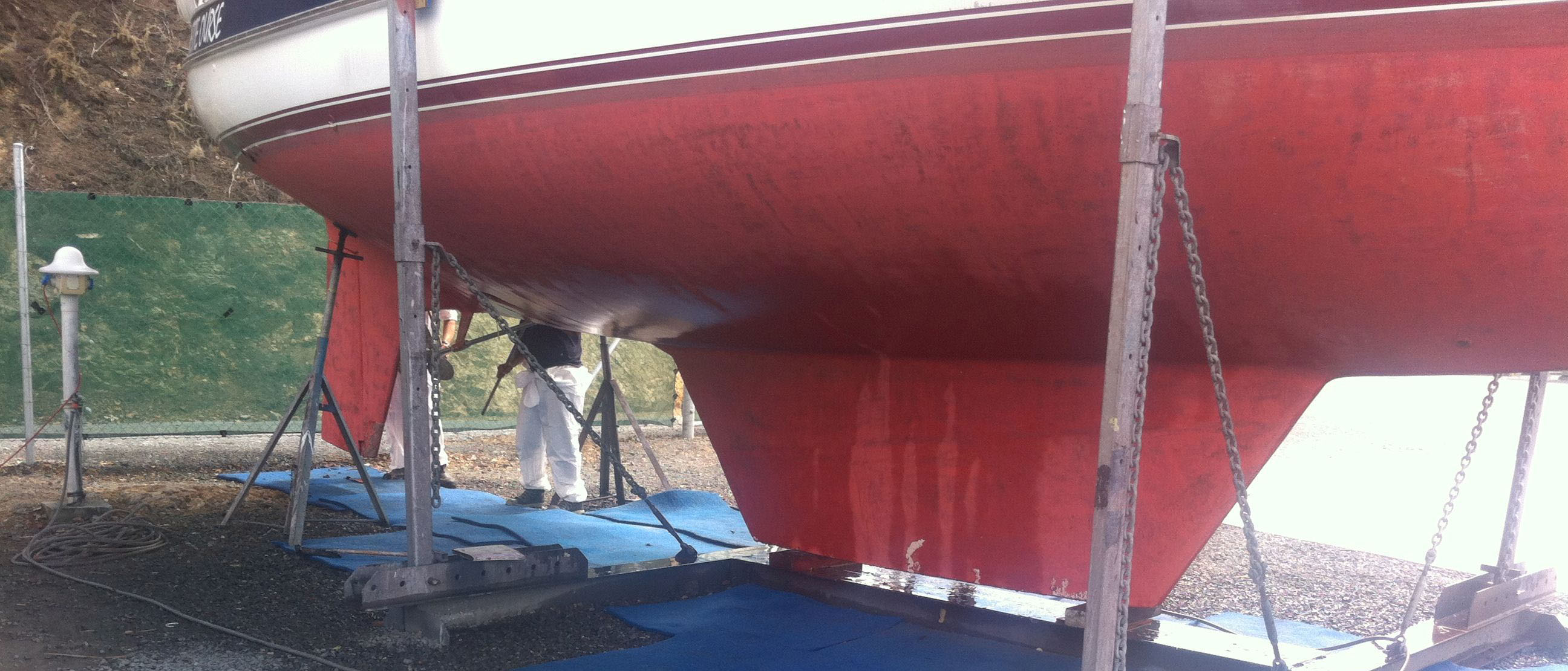 A yacht on a land-based structure during hull cleaning.